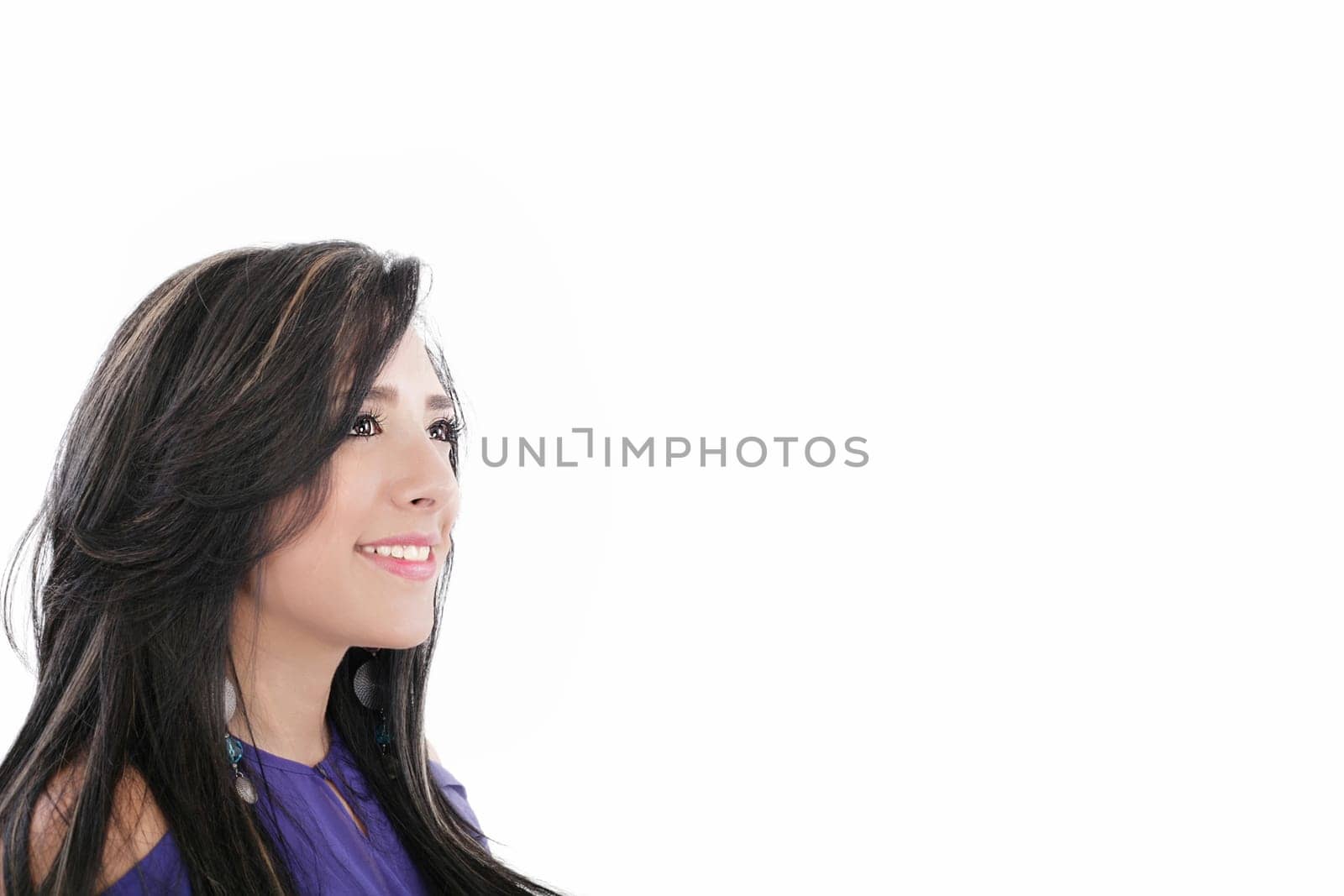 Side view of pretty young woman looking away in a thought against white