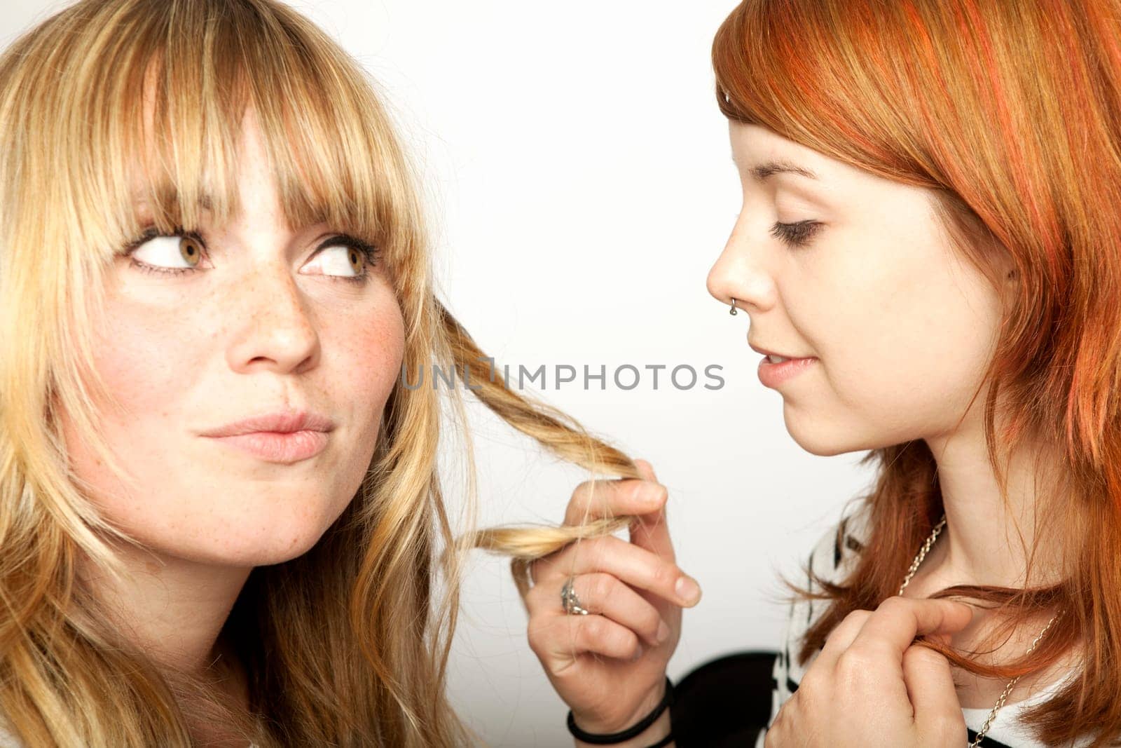 two beautiful girls looking at blond and red hair