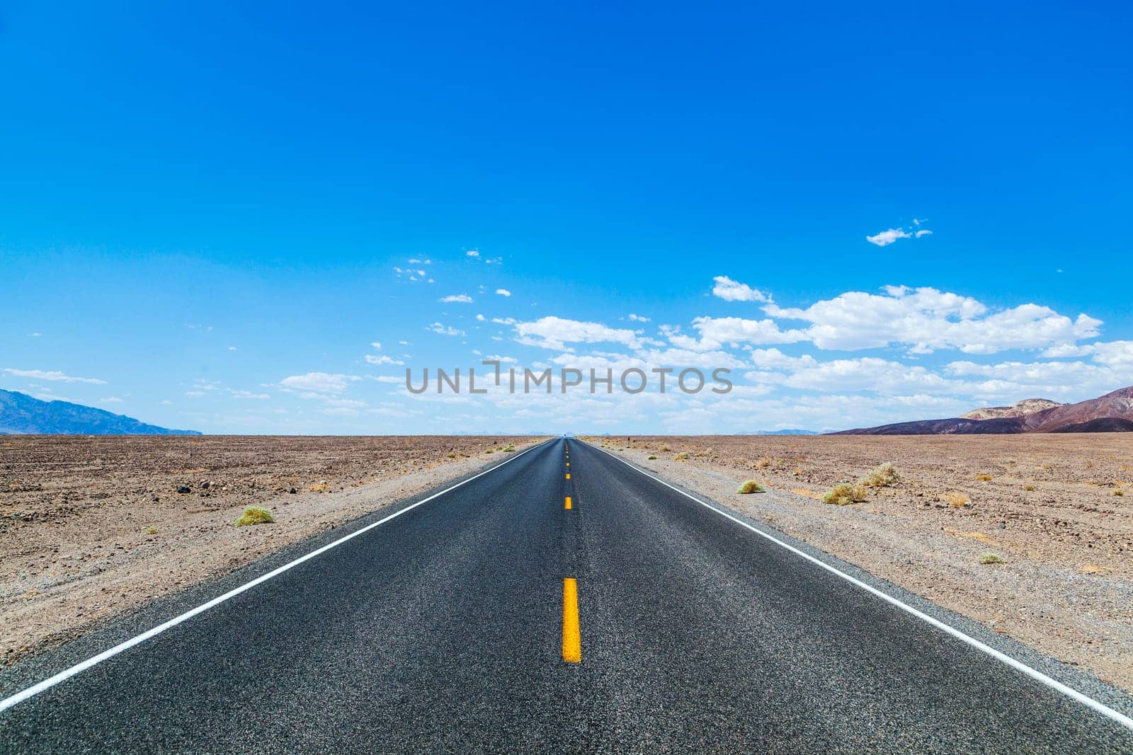 Death Valley road straight across the desert to the mountains in the distance