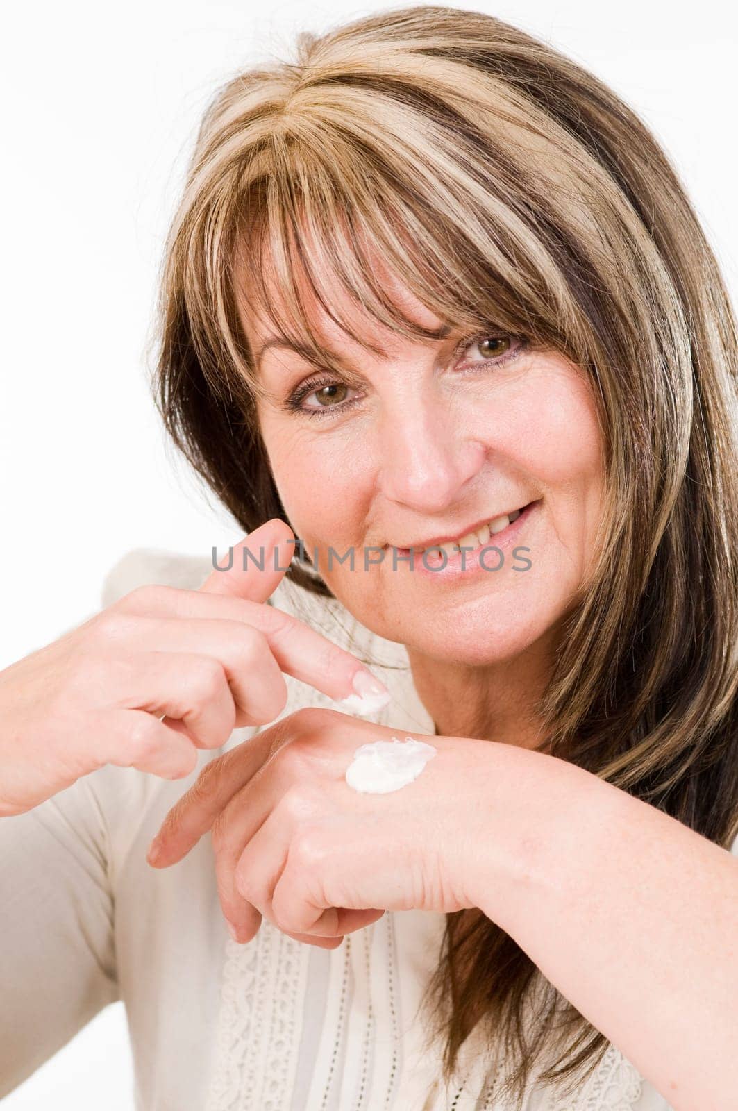 Head and shoulders shot of middle-aged woman with white cream bowls