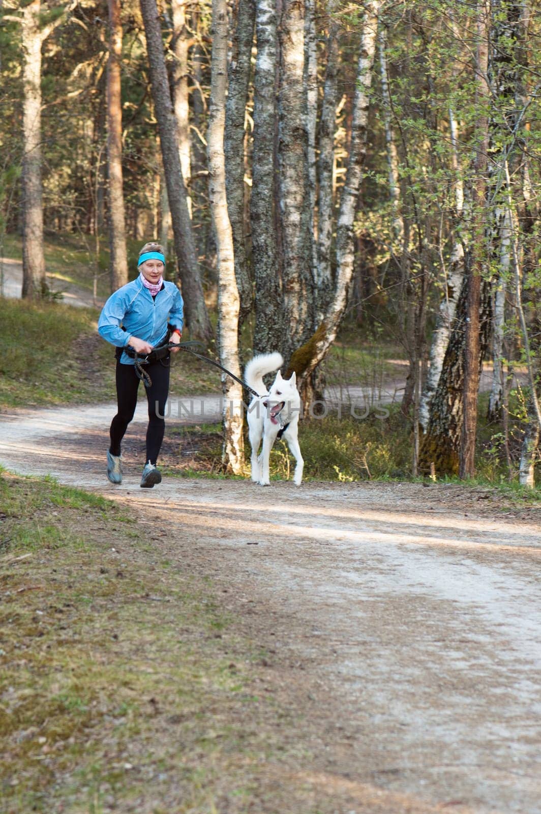 The sports woman with a dog run  in park
