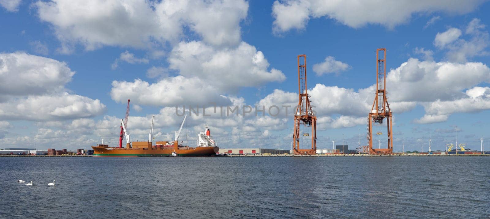 quay in amsterdam harbor with several harbor cranes