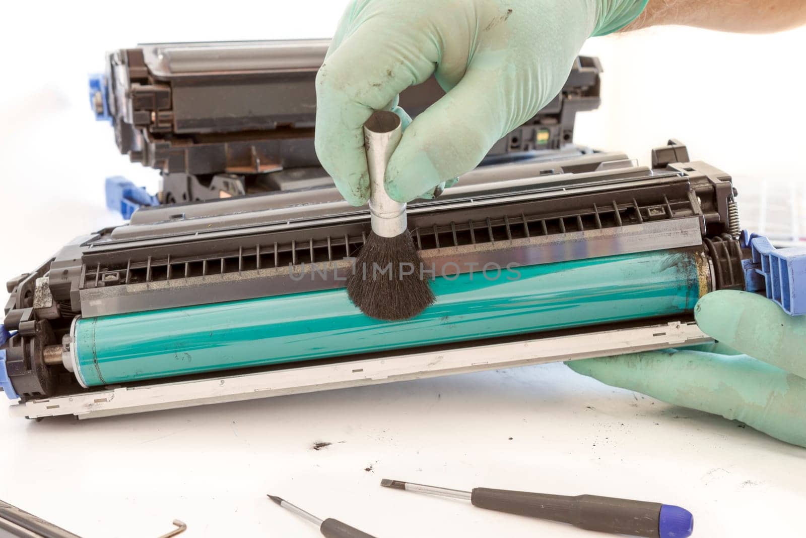 hands cleaning toner cartridge with brush the dust. worker Laser printer on a workbench. Printer workshop
