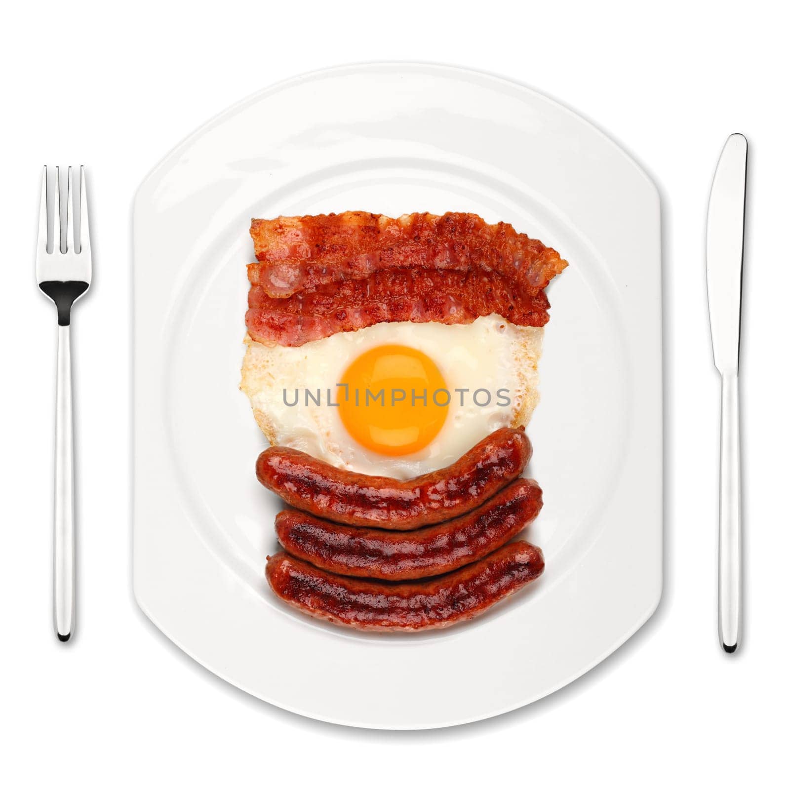 Sausages,fried egg and bacon on a white plate with cutlery.