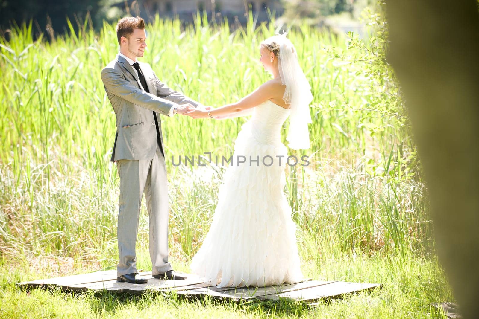 Bride and groom with wedding dress and suit in nature