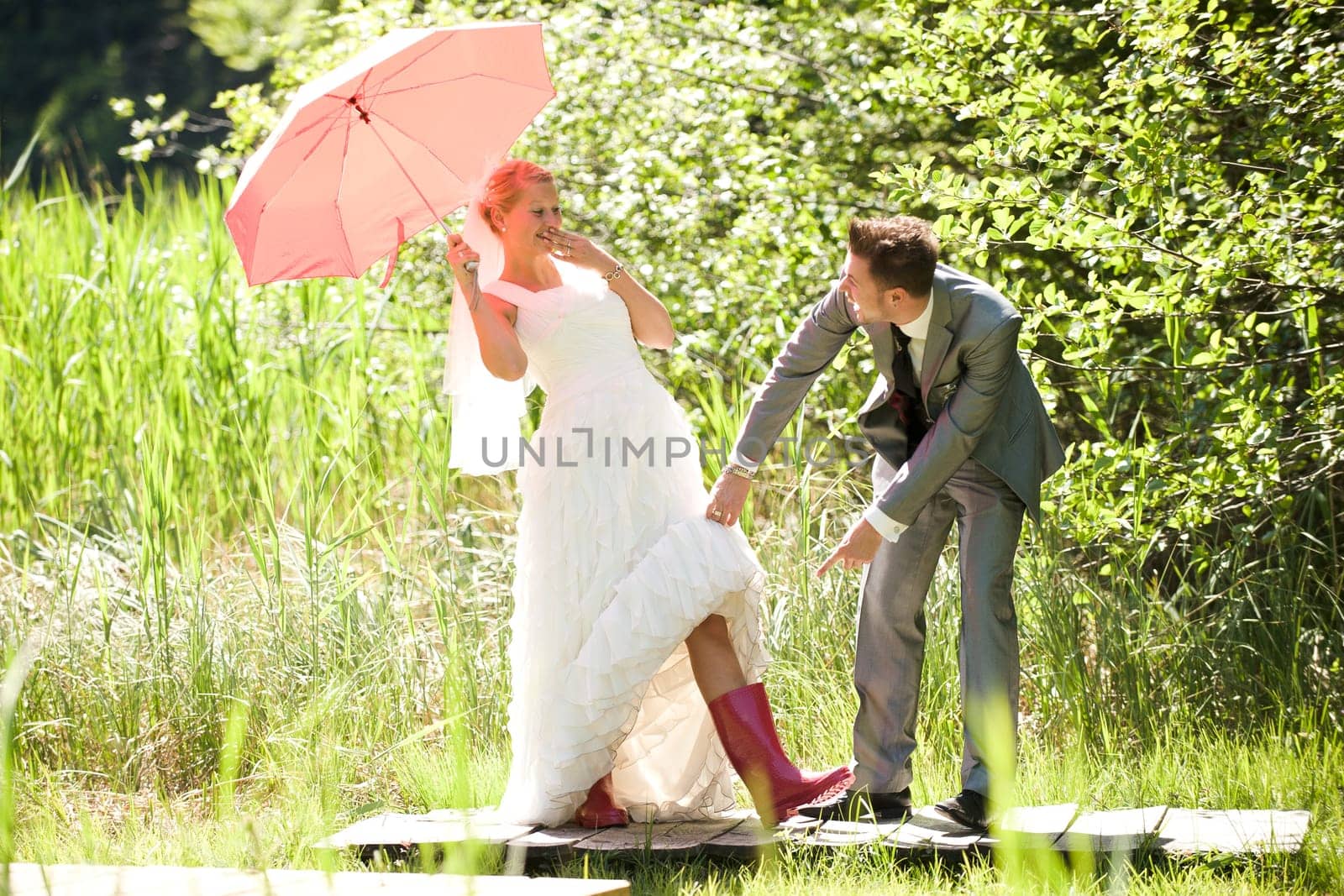 Bride and groom with umbrella and rubber boots