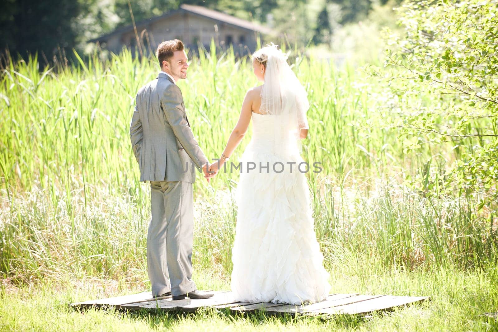 Bride and groom with wedding dress and suit in nature