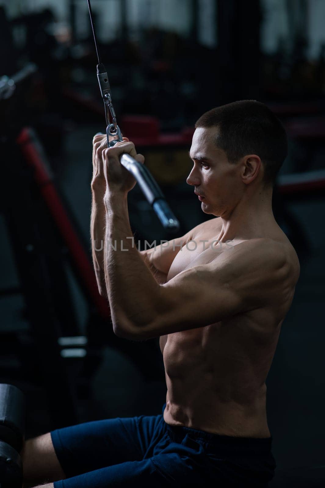 A man does a chest pulldown in the gym