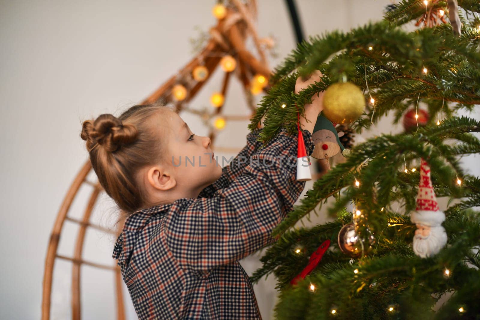 A girl decorates a Christmas tree