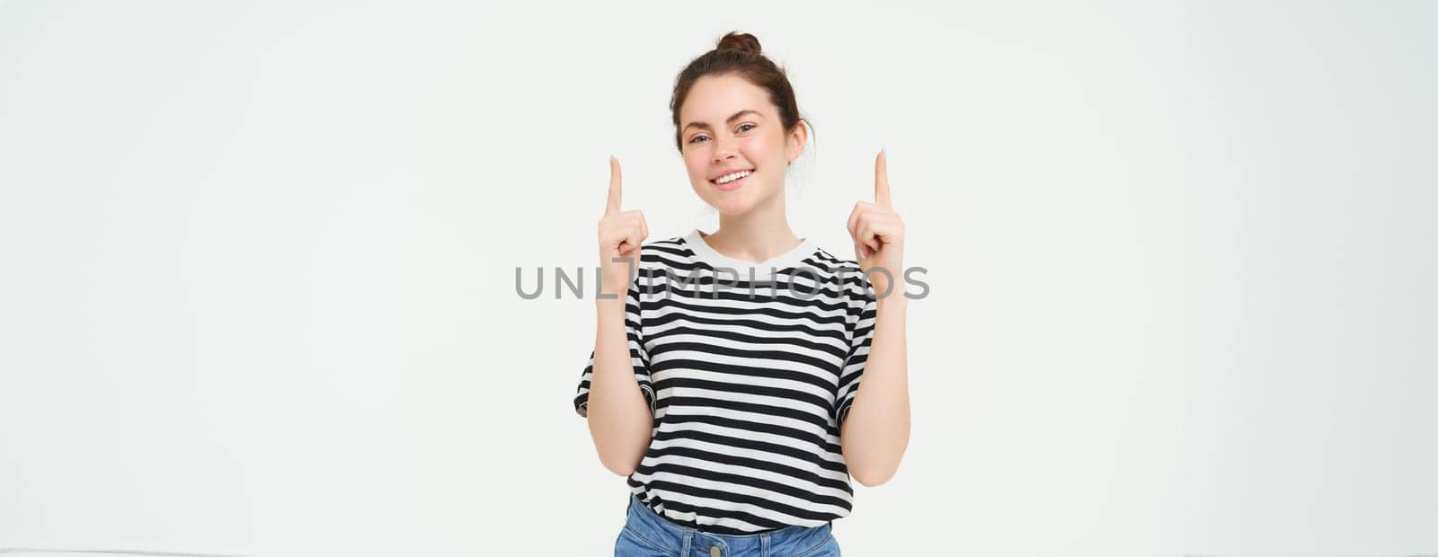 Lifestyle and advertisement concept. Young smiling woman, modern girl, pointing finger at promo, showing banner, place with text, isolated on white background.
