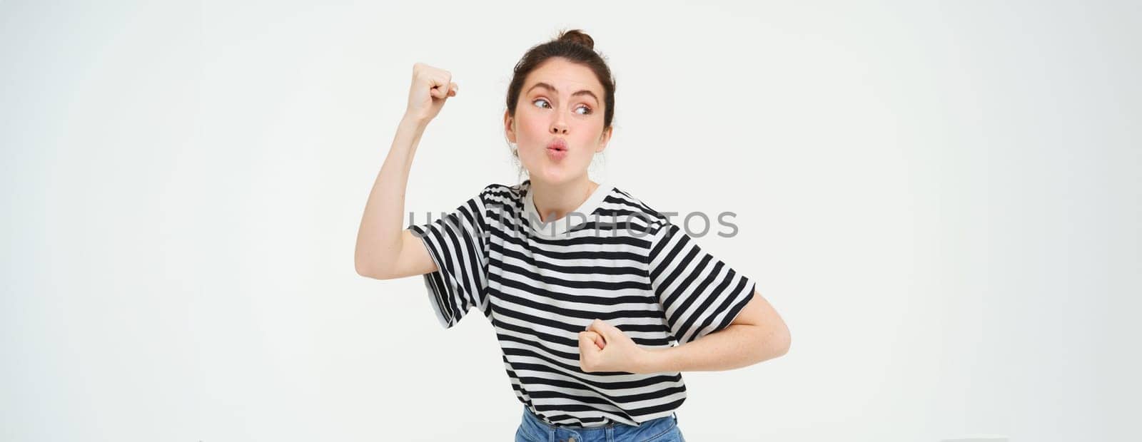 Image of excited young girl cheering, raising hands up, screams from excitement and happiness, winning, celebrating victory, standing over white background by Benzoix