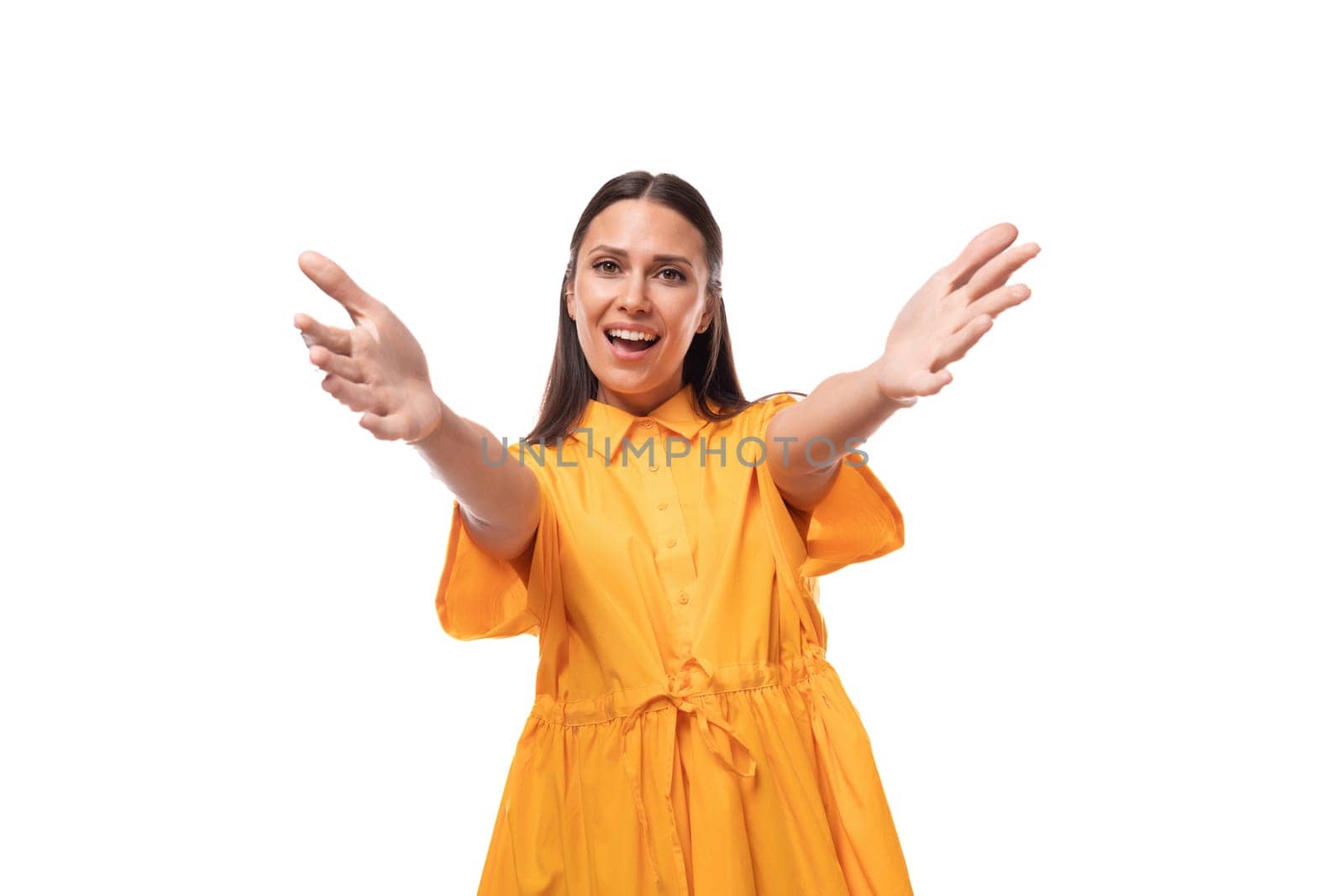 young friendly brunette woman dressed in a summer yellow dress attracts attention by TRMK