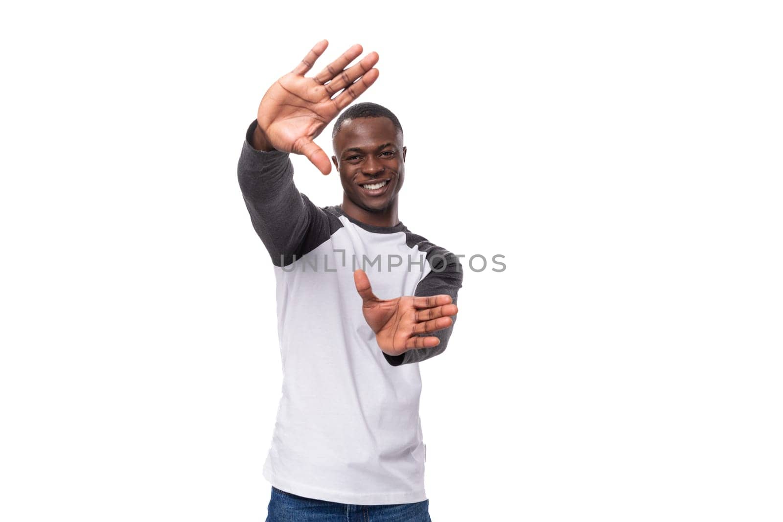 young kind handsome american man dressed in a black and white jacket with long sleeves smiling on a white background.