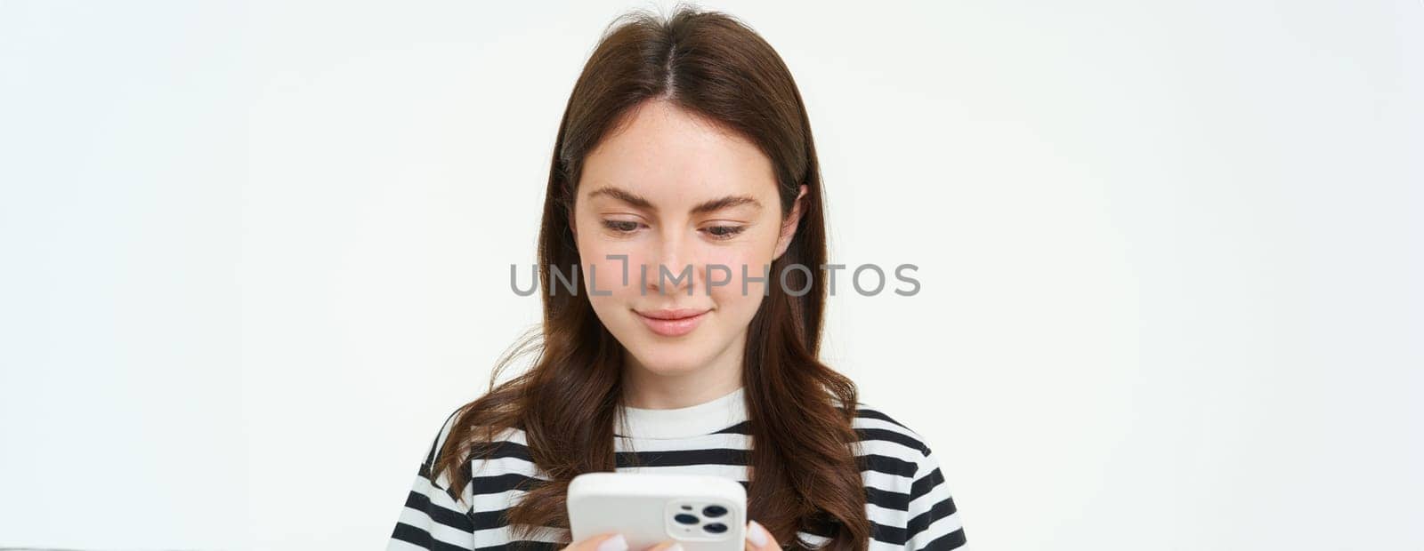 Portrait of woman checking her messages on mobile phone, looking at smartphone screen.