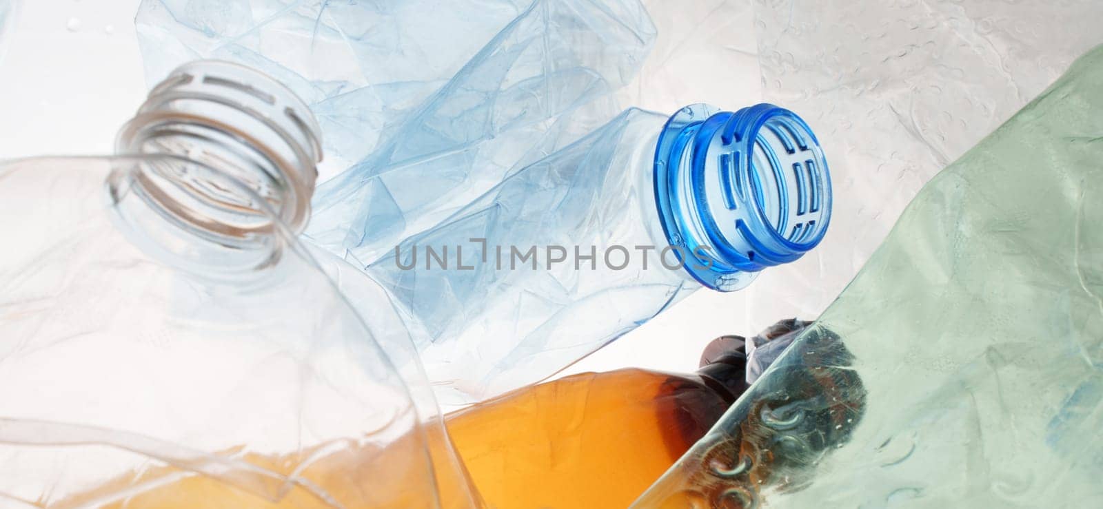 Many transparent bottles color plastic PET recycling waste. Empty plastic bottles background. Pile of empty bottle recycling plastic material recyclable waste sorting. Recyclable trash recycle garbage by synel