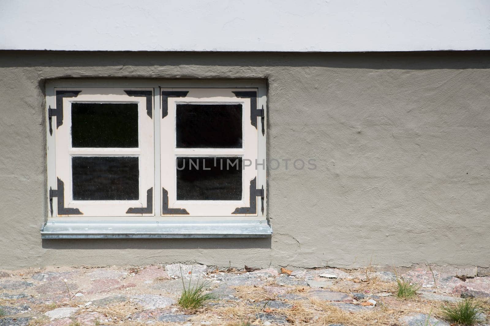 Stony house with filled wall and white window