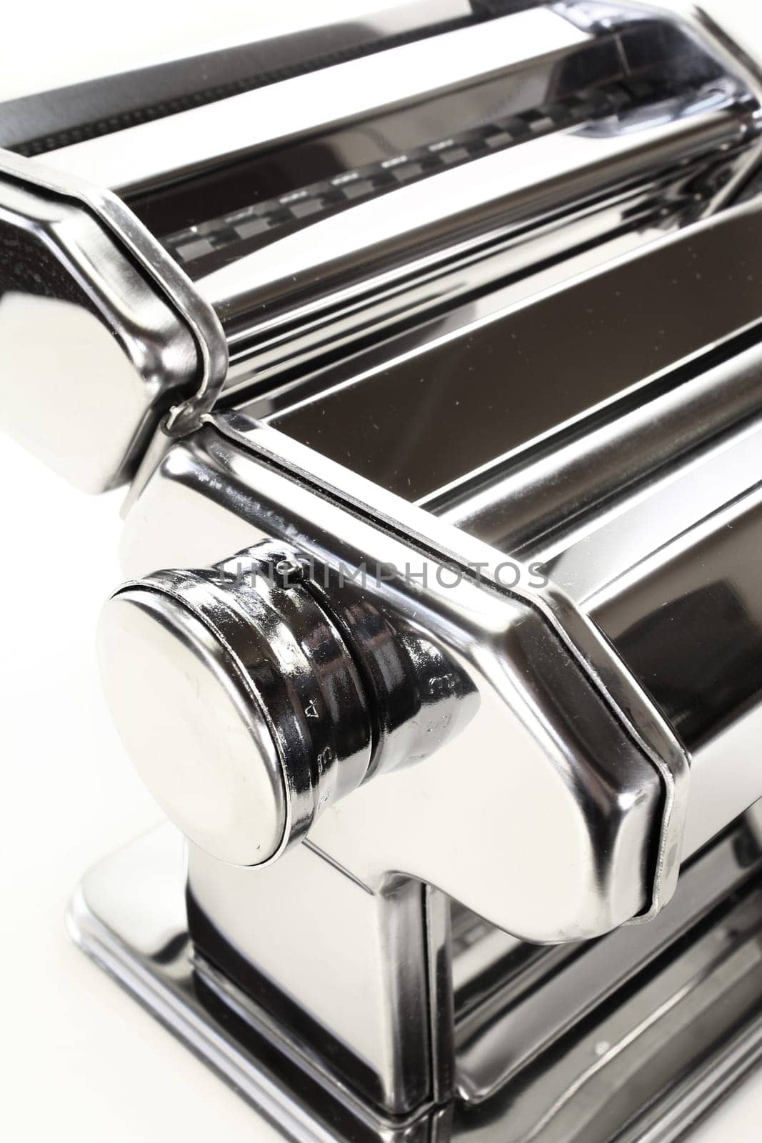 A detail of a pasta machine against a white background