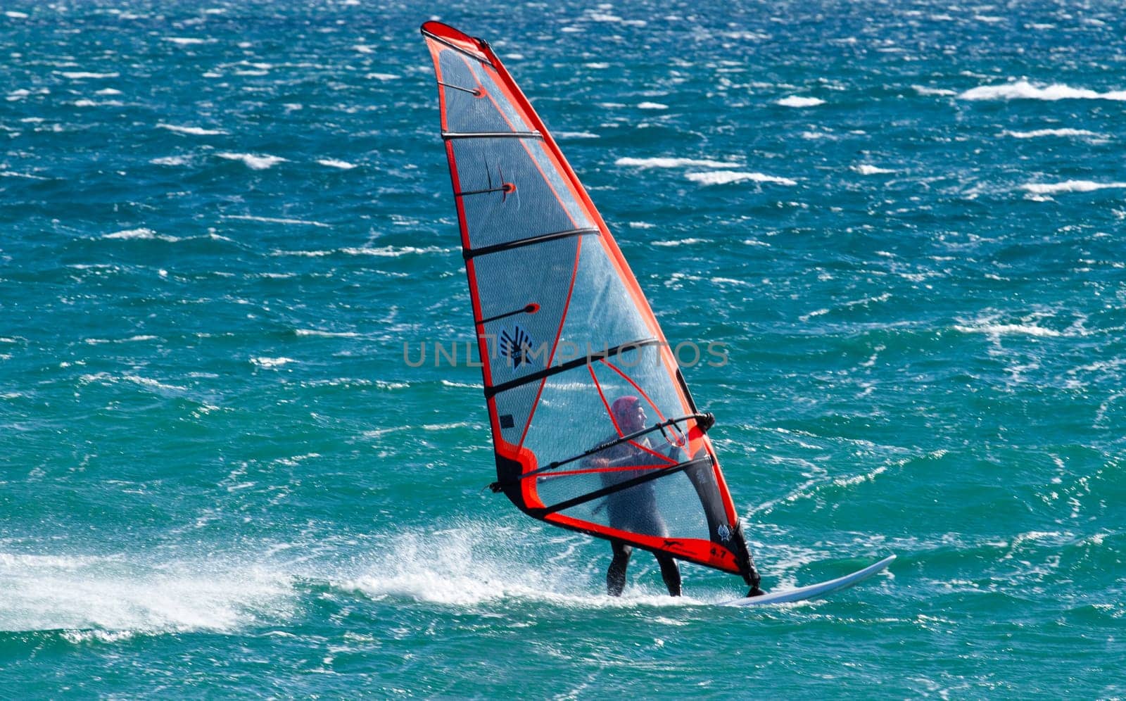 young man surfing the wind on summer day