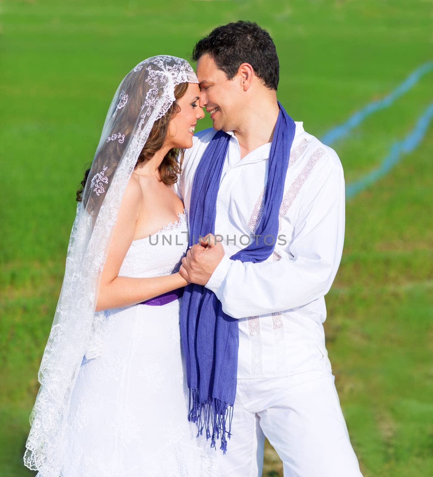 Couple in wedding day hug in outdoor green meadow