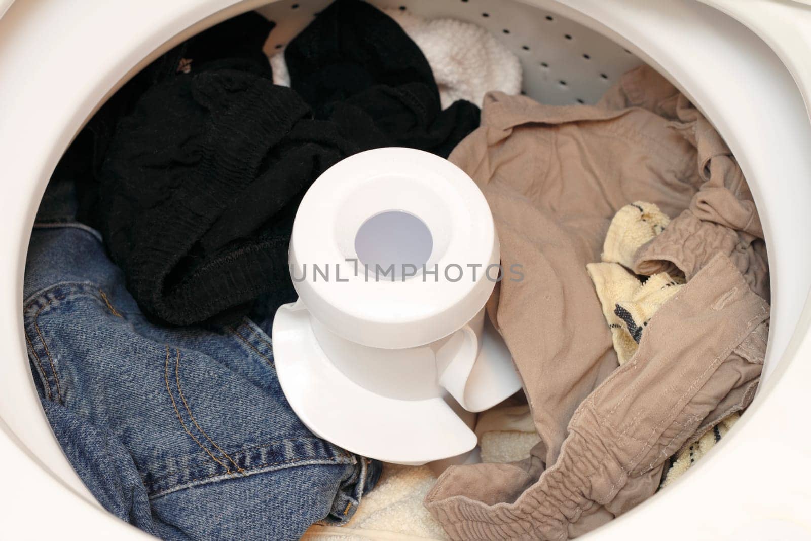Damp washed laundry sitting in the washing machine ready to be put in the dryer.