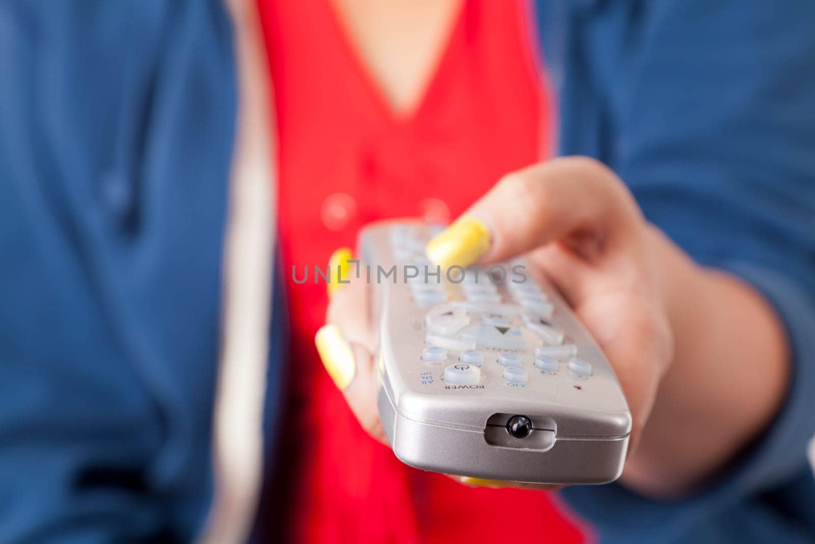 Closeup image of a hand holding remote control