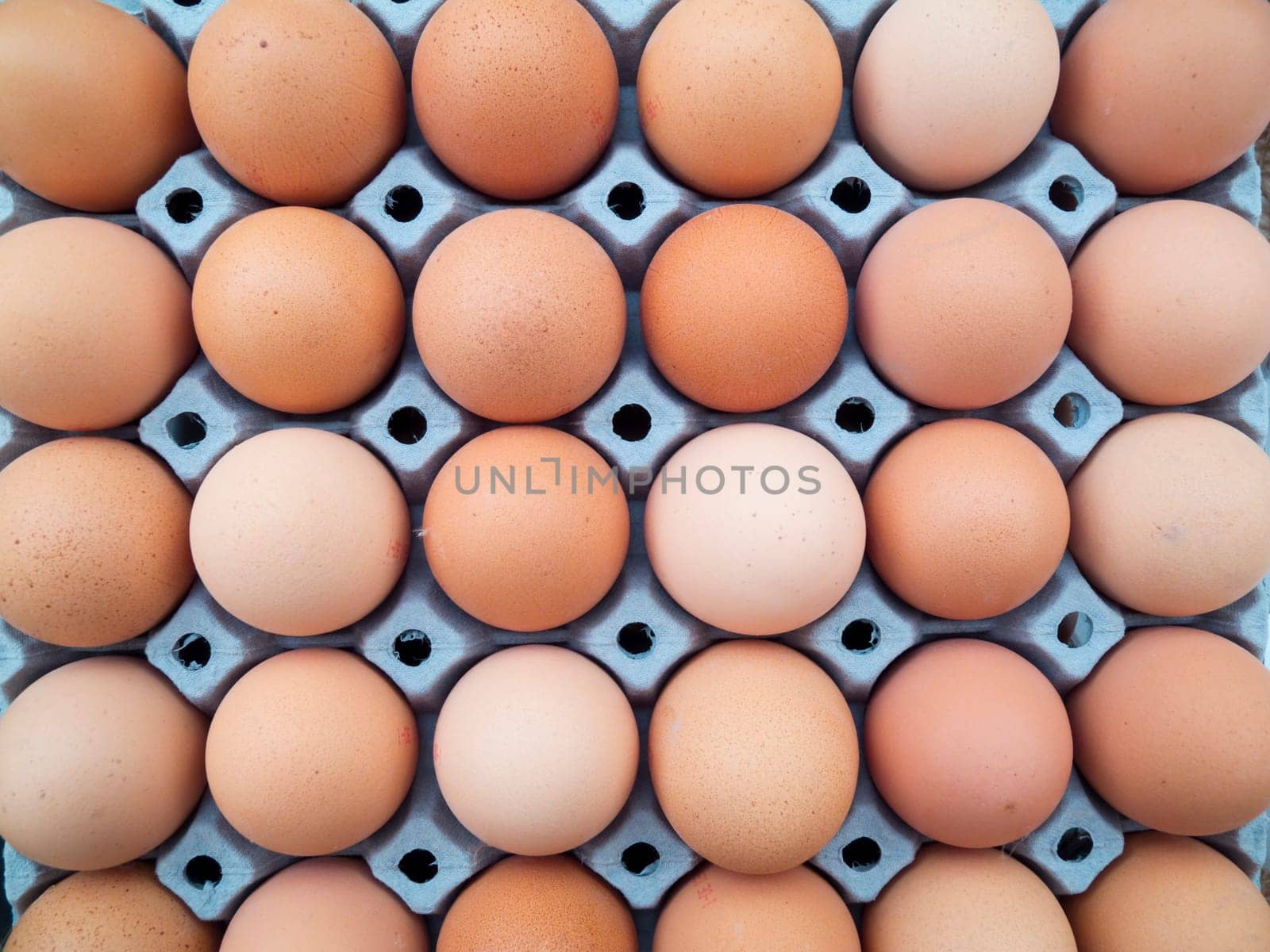 Brown eggs in an egg carton in top view