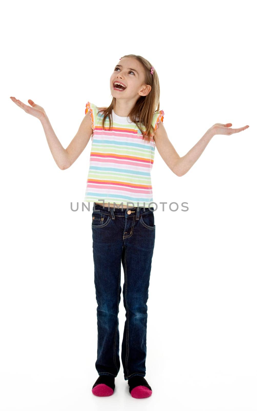 Studio photo of little girl standing with arms extended as though juggling, on white background.