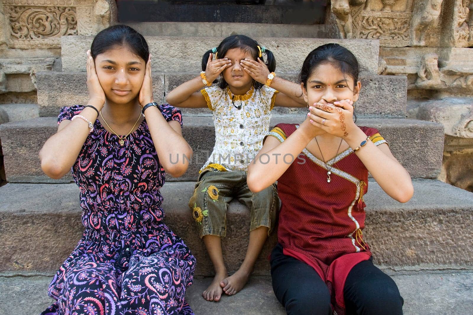 Girls enacting concept of "Hear no evil, see no evil and speak no evil"""