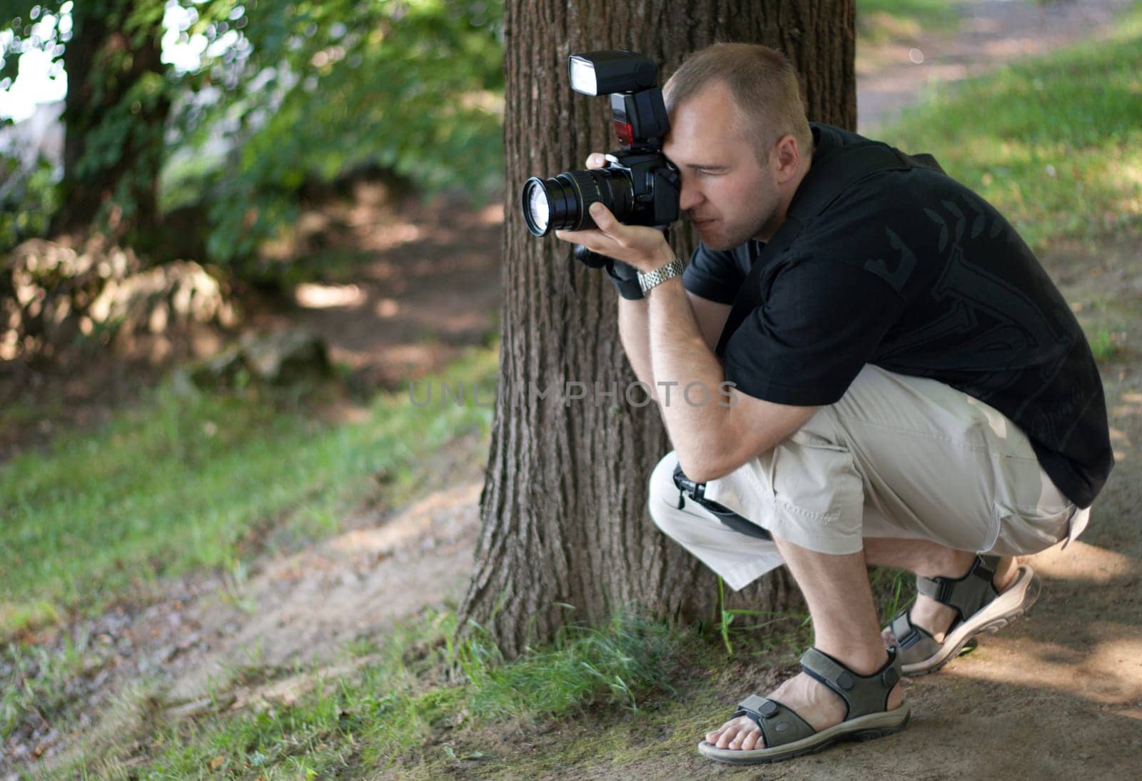 Man in duck blind with photocamera, reporting