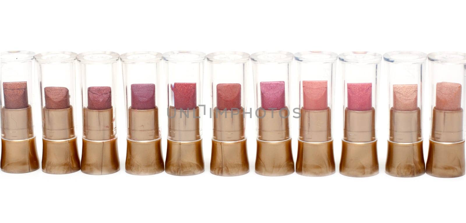 Lipstick in plastic case stands in row on white background