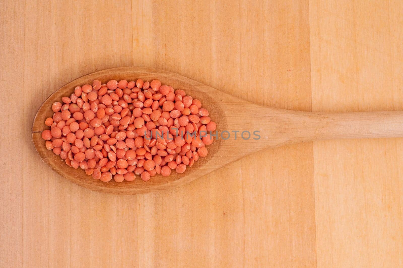 Close-up wooden spoon with red lentils