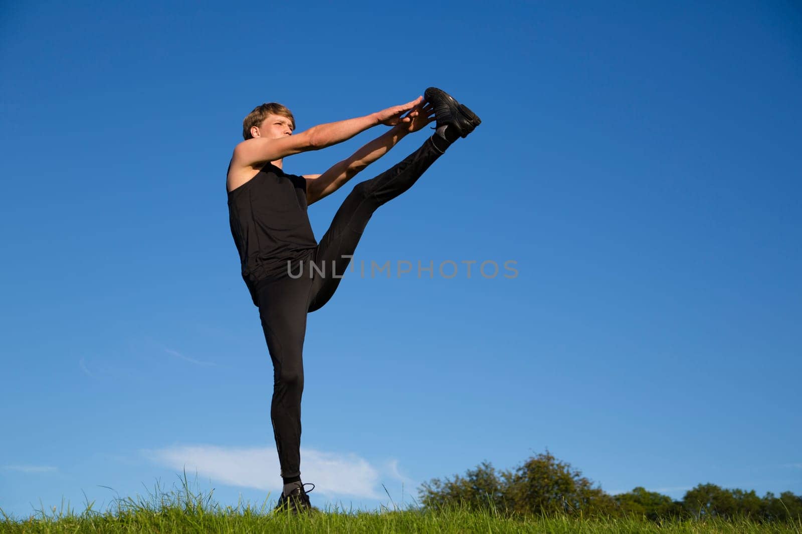 Sportsman is stretch left leg and lift high