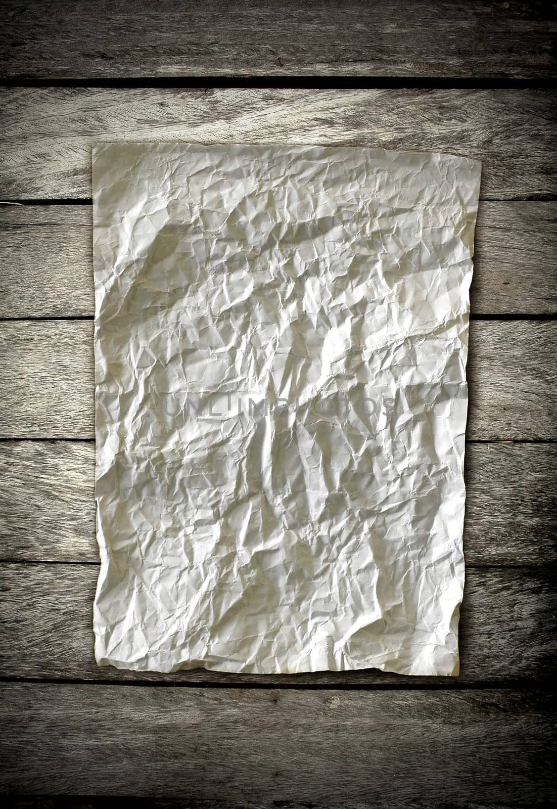 old crumpled paper on wooden wall