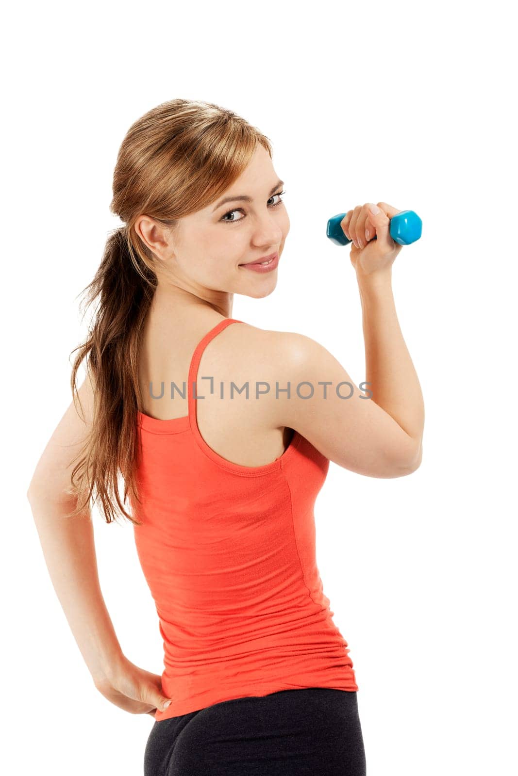 Cute sportswoman with fitness dumbbell looking over shoulder against white background