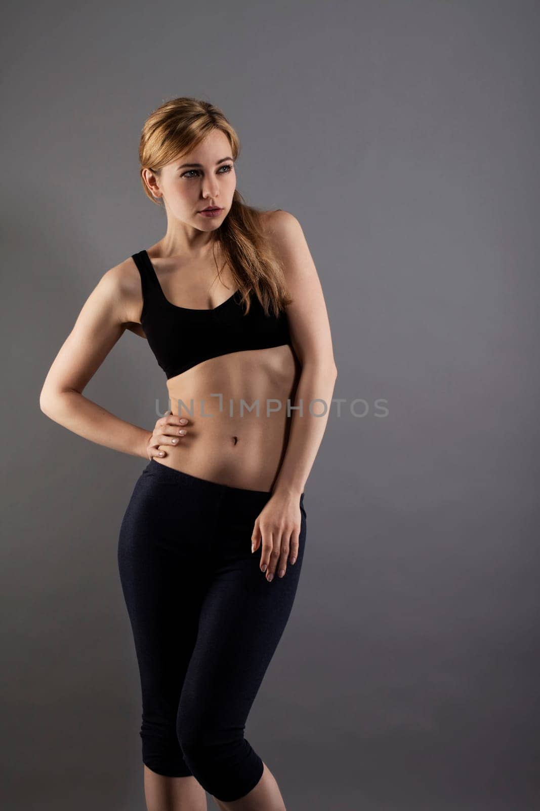 Young sportswoman with black fitness dress in fashion pose