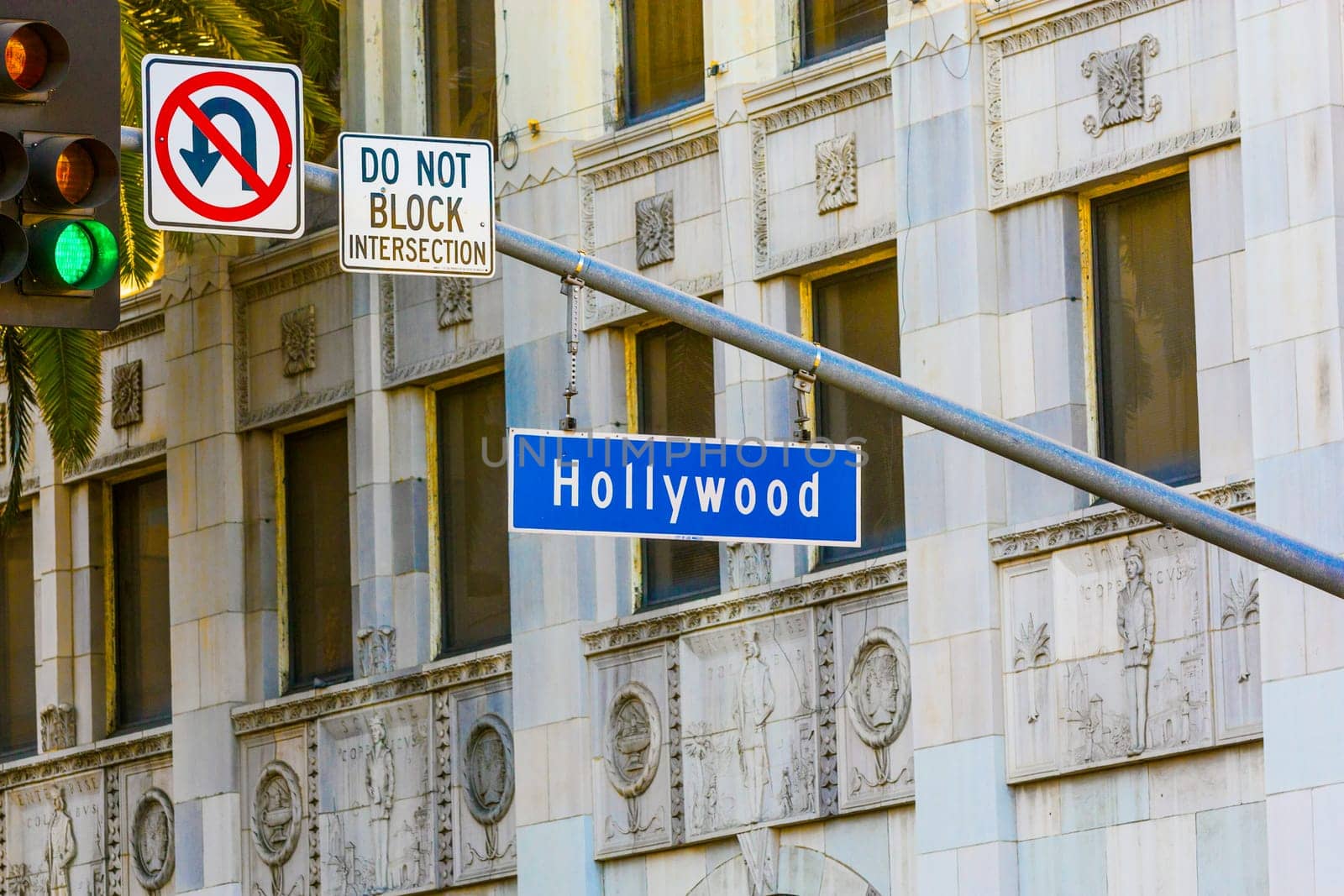 Hollywood Blvd street sign with tall palm trees.