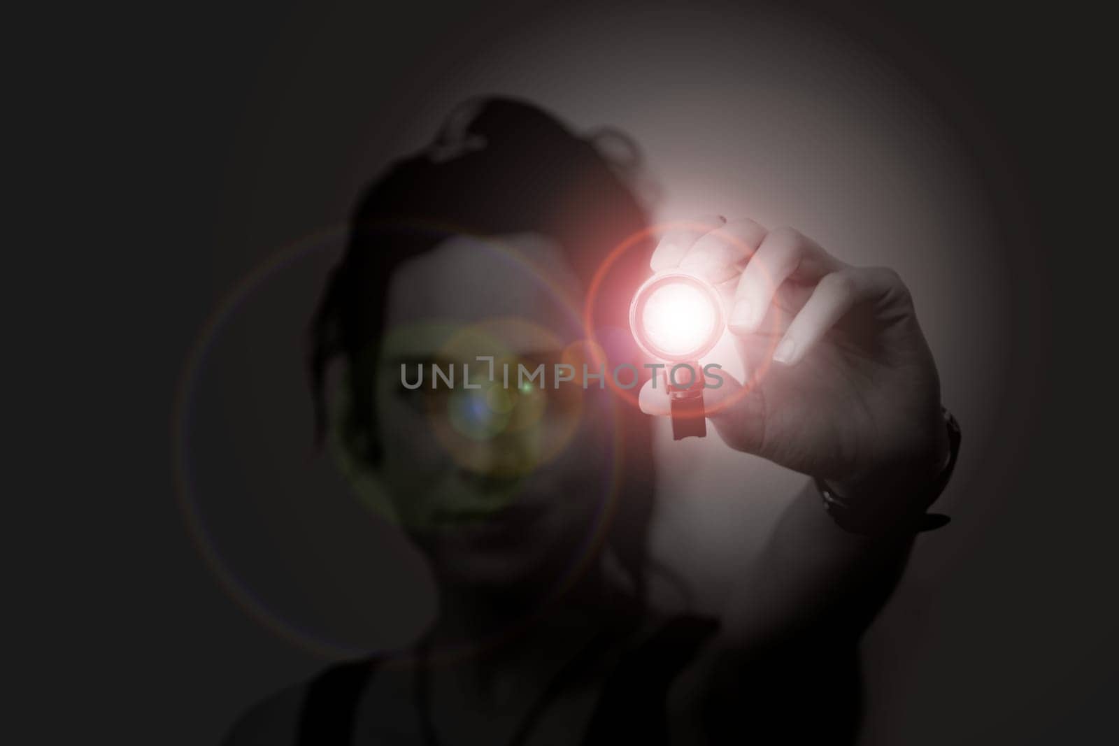 young woman holding a led flashlight at night