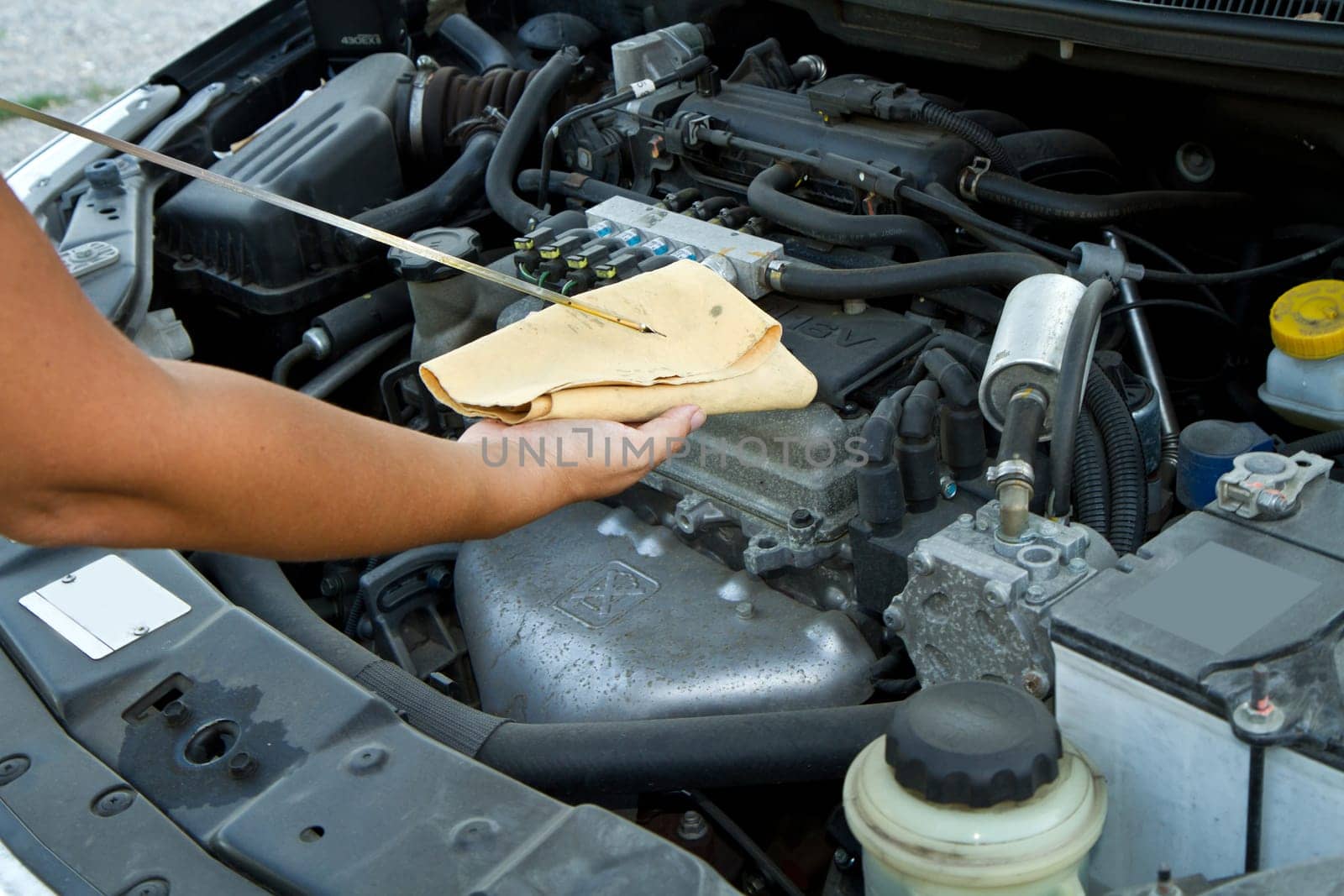 Auto mechanic checking oil