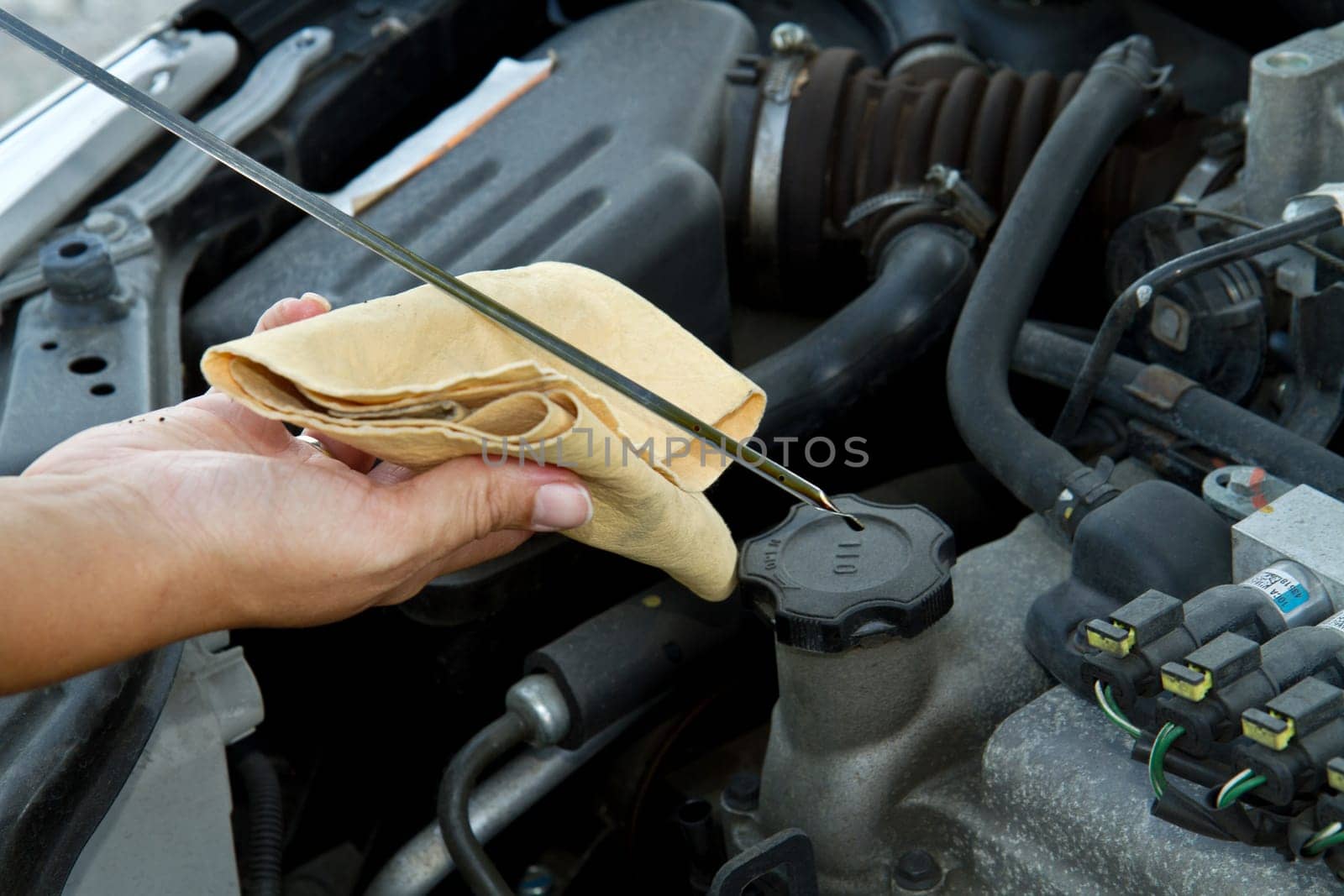 Auto mechanic checking oil