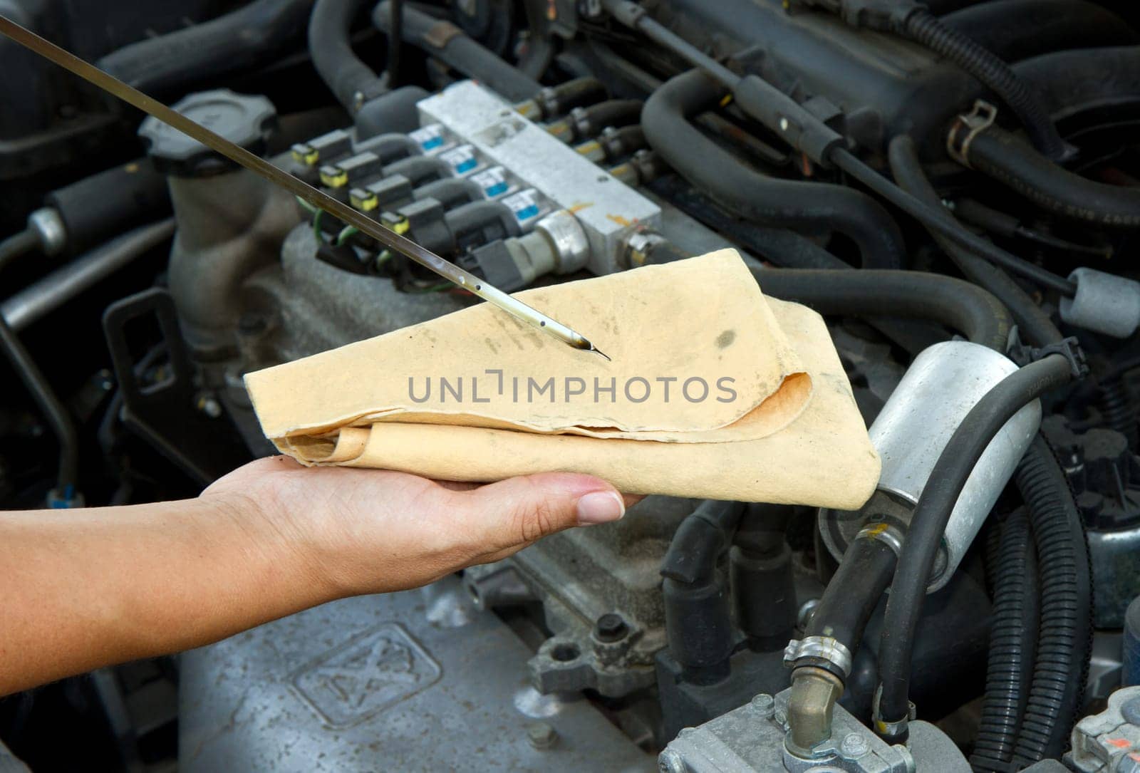 Auto mechanic checking oil