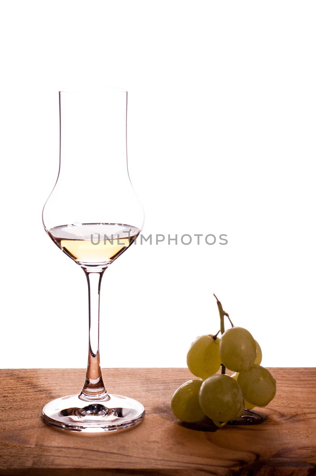 Italian grappa and grapes on a wooden board