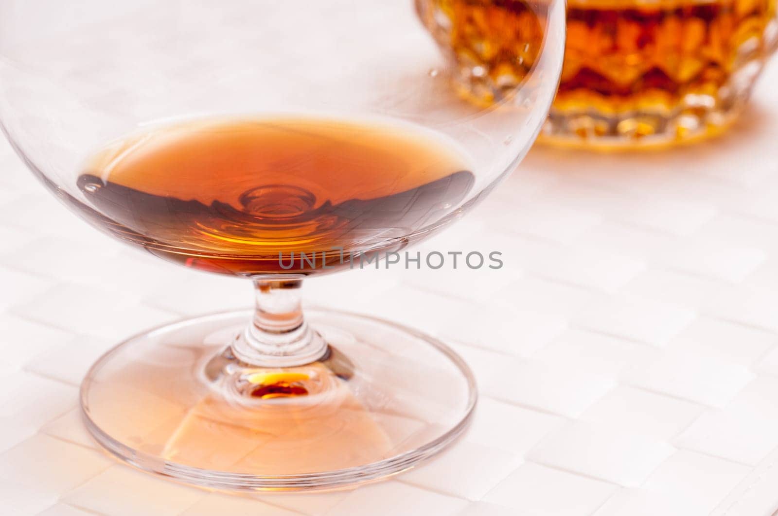 Brown brandy in a cognac swirl on a white background