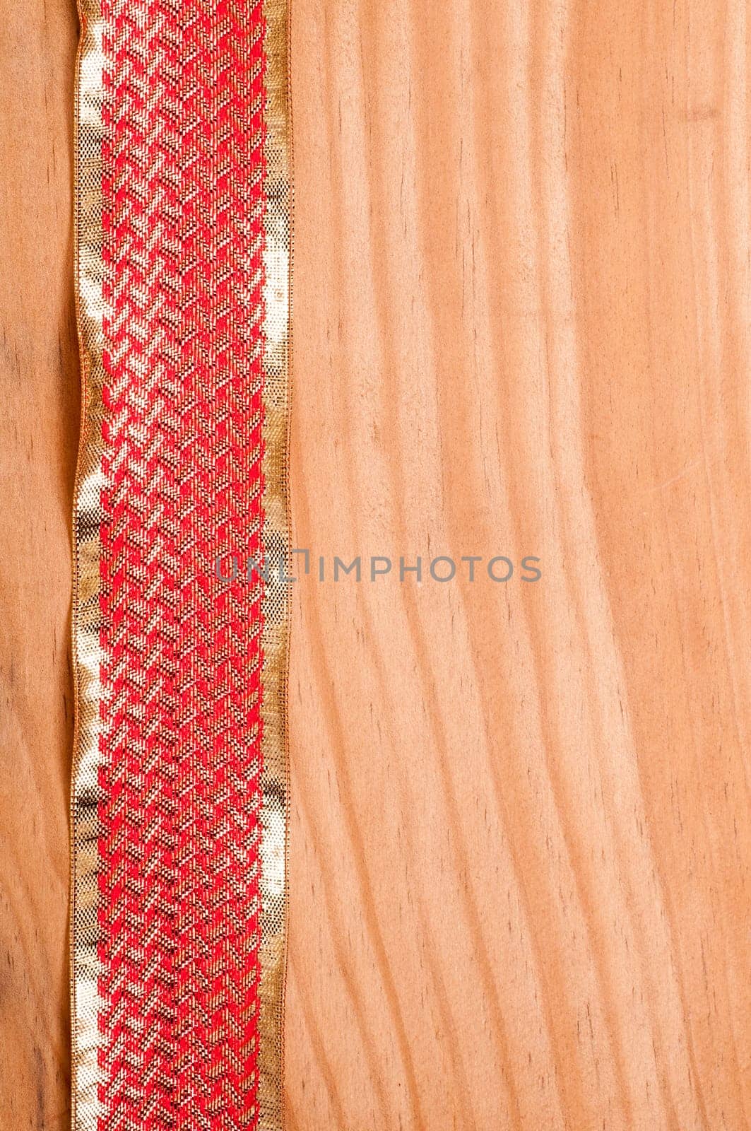 Wooden board with gold and red ribbon as background