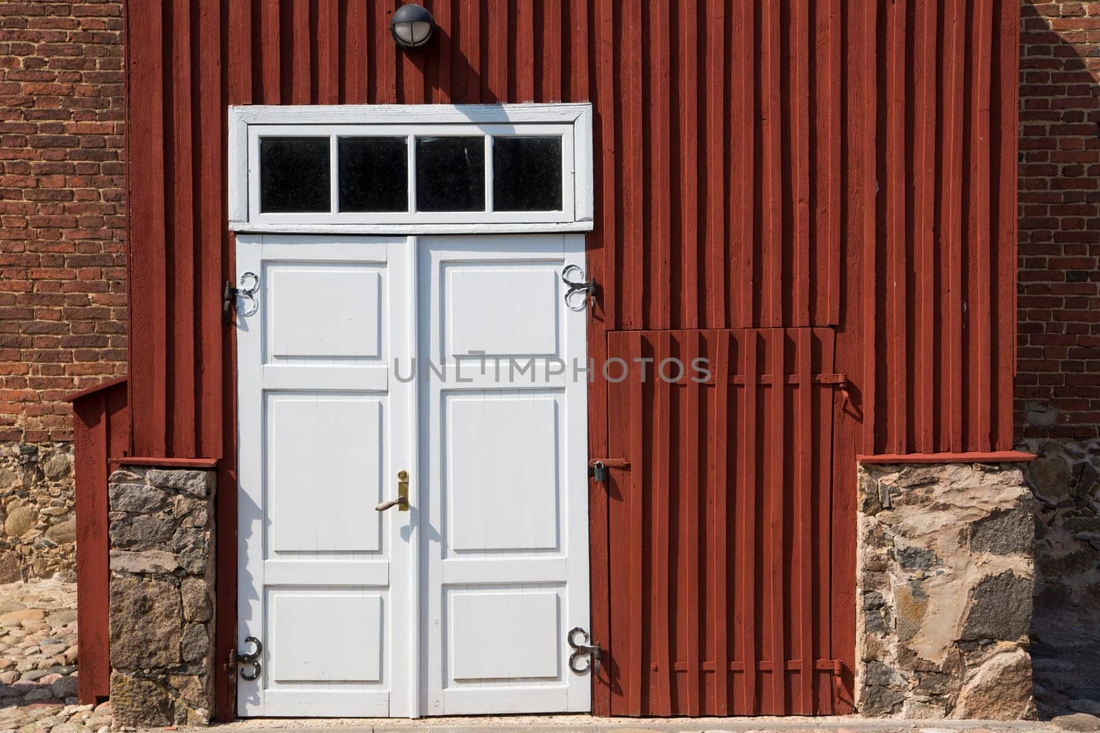Wooden door in front of stony brick house