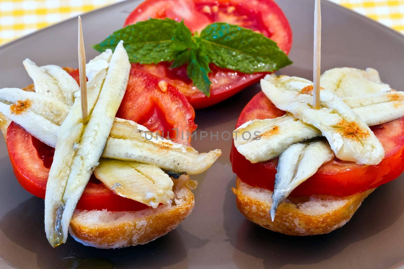 skewer of pickled anchovies, adorned with tomato and mint, cover typical Spanish
