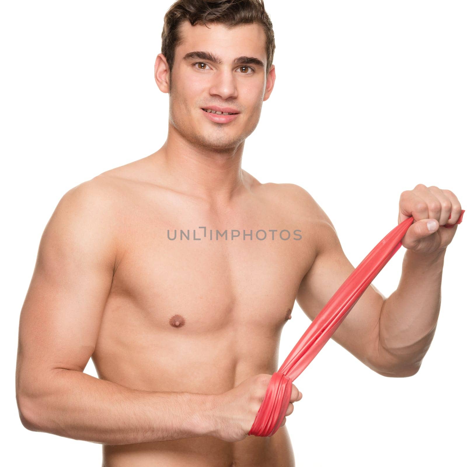 Young man with a red gymnastics band against a white studio background
