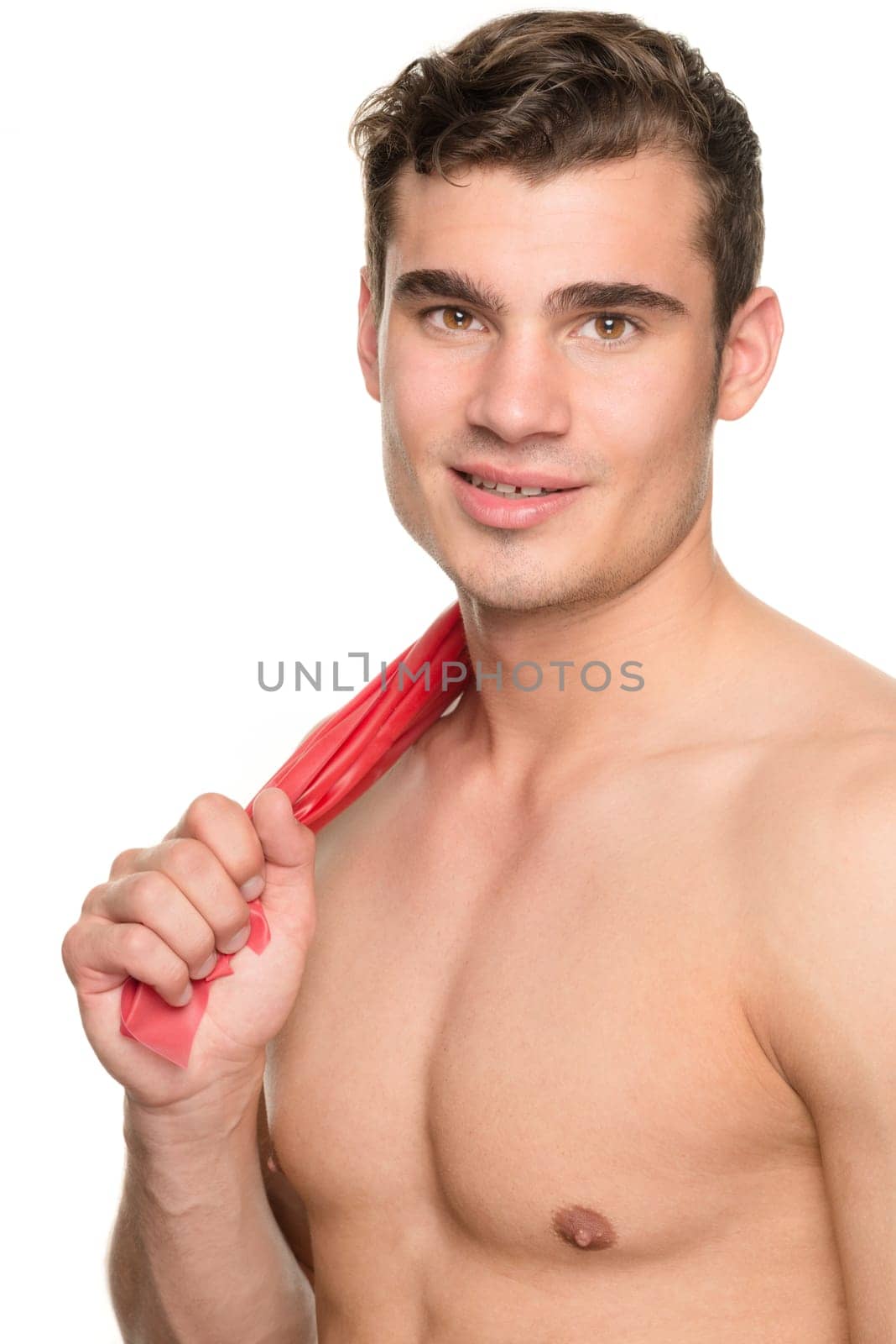 Young man with a red gymnastics band against a white studio background