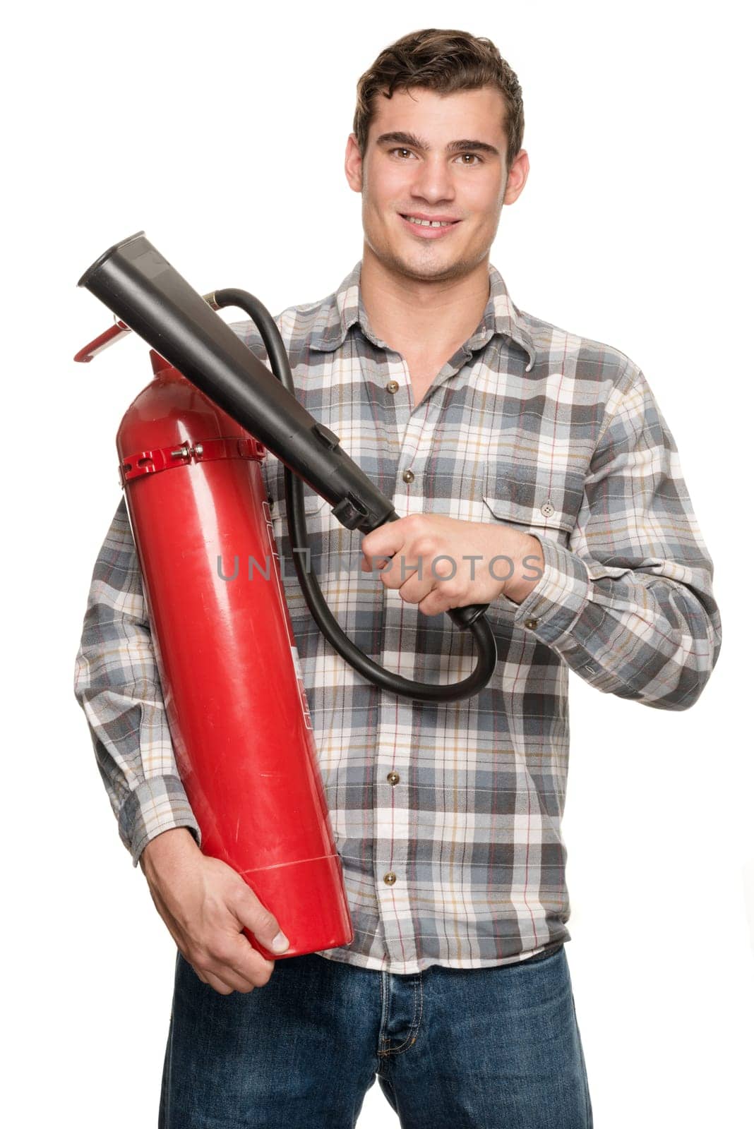 Young man with a fire extinguisher in front of a white studio background