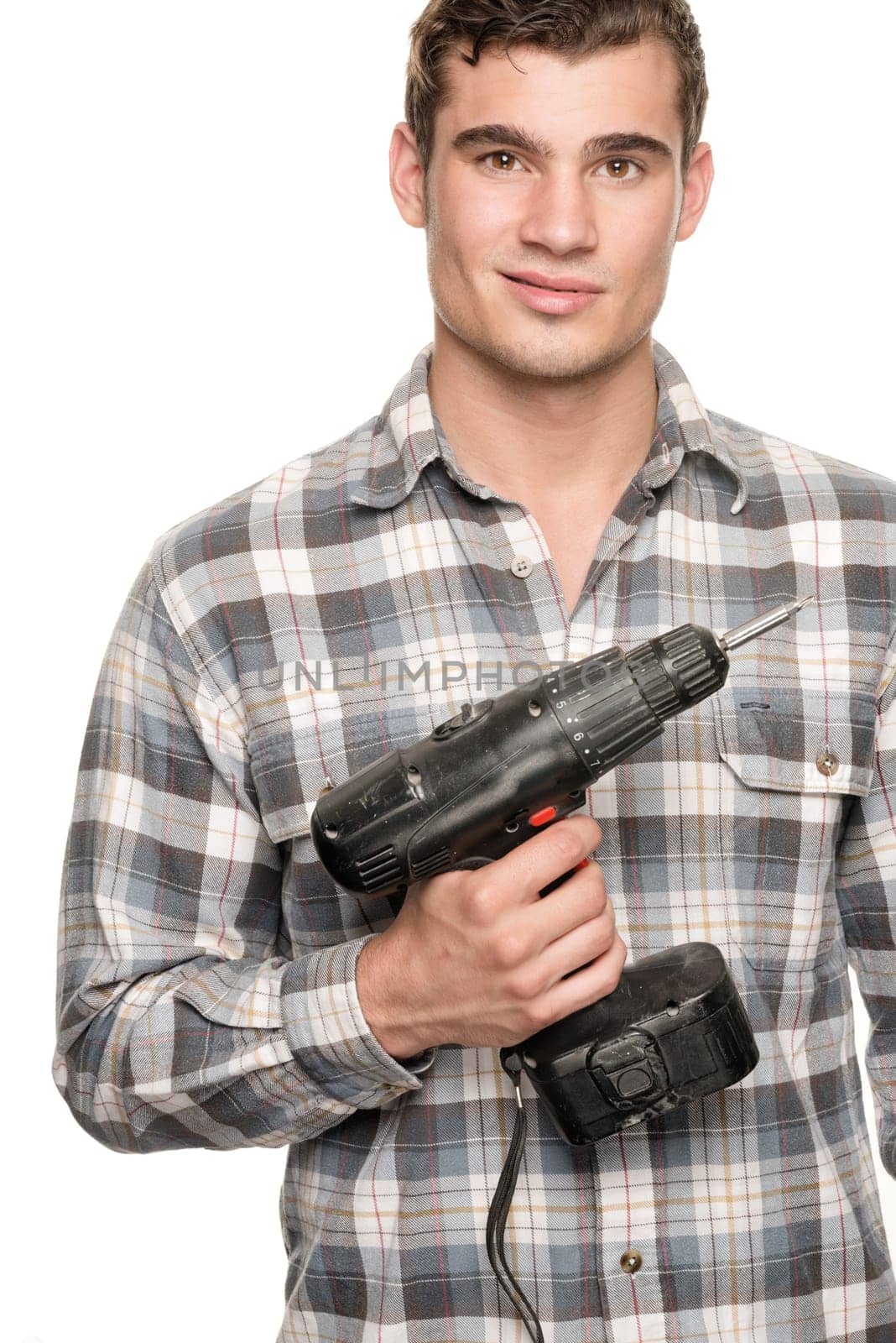 Young man with cordless screwdriver in front of white studio background