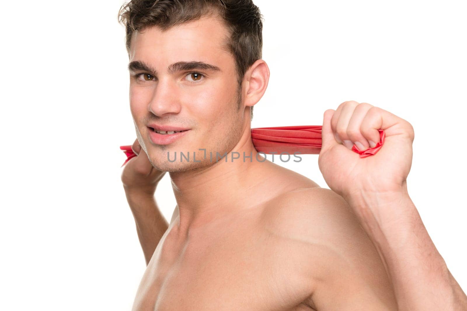 Young man with a red gymnastics band against a white studio background